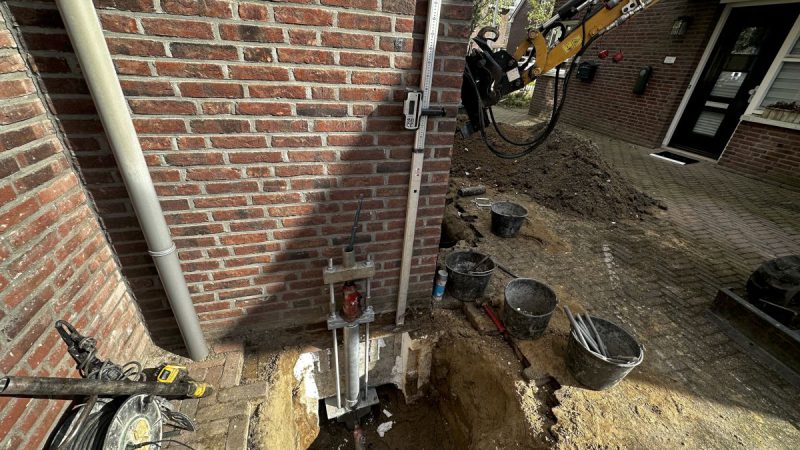 De fundering wordt in de grond naast een huis gezet.